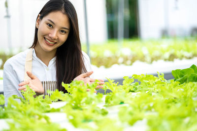 Portrait of young woman holding plant