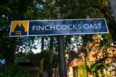 Low angle view of road sign against trees