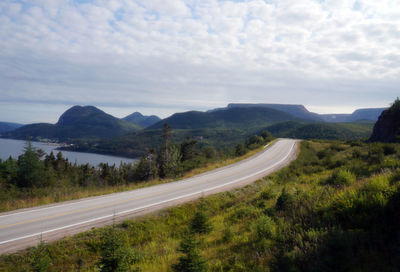 Road leading towards mountains against sky