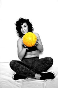 Portrait of woman sitting against white background