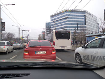 Cars on road against sky in city