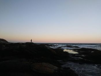 View of calm beach against clear sky