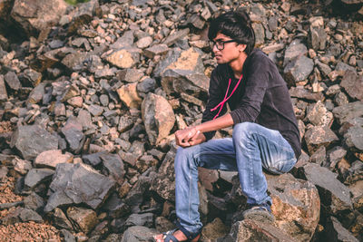 High angle view of woman sitting on rock