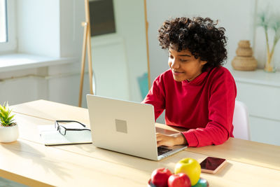 Young woman using laptop at table