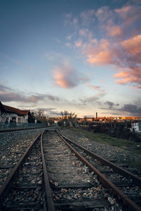 Railroad tracks against sky at sunset