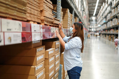 Side view of woman standing at warehouse