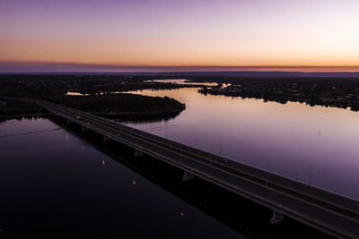 Bridge over river against sky during sunset