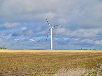 Windmill on field against sky