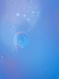 Close-up of bubbles against blue water