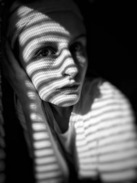 Close-up portrait of young woman lying at home