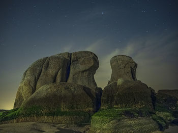Low angle view of rock formation against sky at night