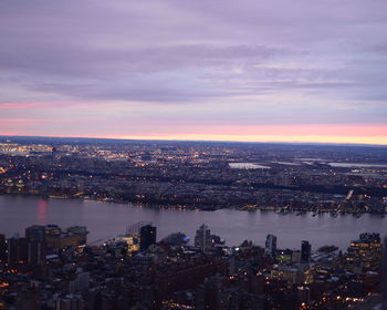 Aerial view of east river amidst building against cloudy sky at sunset