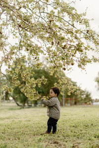 Rear view of woman standing on field