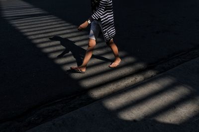 Low section of woman walking on street