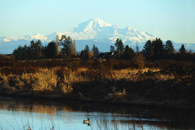 Scenic view of lake by mountains against sky