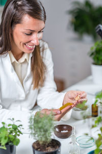 Young woman looking away while sitting on table