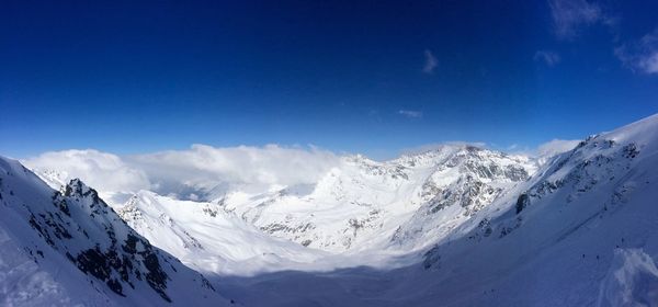 Scenic view of snowcapped mountains against blue sky