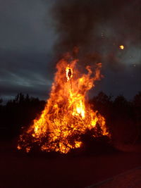 Bonfire on field against sky at night