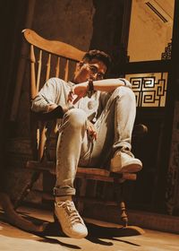 Portrait of young man sitting on chair at home