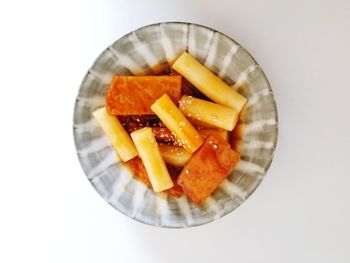High angle view of chopped slices in bowl against white background