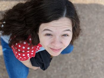 Directly above portrait of smiling young woman on road