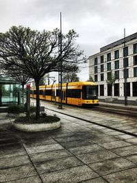 Cars on road against sky in city