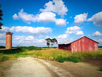 View of field against cloudy sky