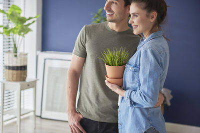 Young couple standing against wall