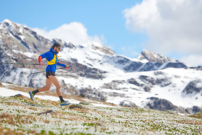 Mountain runner with chopsticks in downhill training