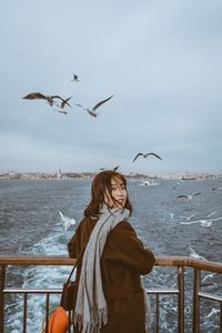 Low angle view of seagulls flying over sea against sky