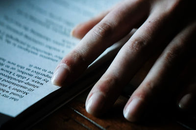 High angle view of hand on book