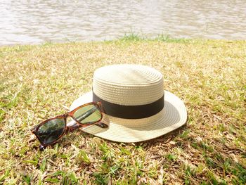 Straw hat with sunglasses on riverbank