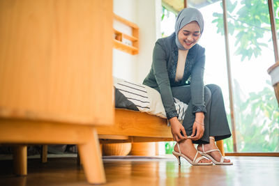 Portrait of young woman standing at home