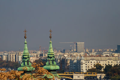 Buildings in city against clear sky