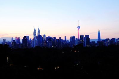 Buildings in city against sky during sunset