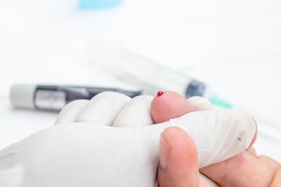 Close-up of doctor holding bleeding finger