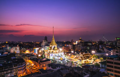 High angle view of illuminated stupa amidst buildings in city at night