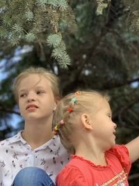 Portrait of mother and girl looking at tree