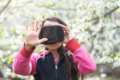 Happy amazed little girl wearing virtual reality goggles watching movies or playing video games. 