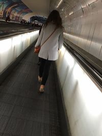 Woman standing on escalator