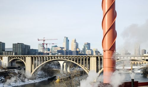 Bridge over river against buildings in city