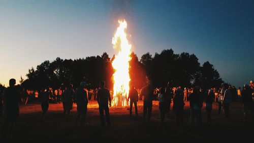 Large bonfire surrounded by people