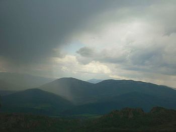 Scenic view of mountains against storm clouds