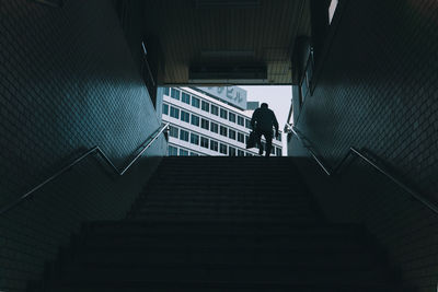 Rear view of man walking on staircase