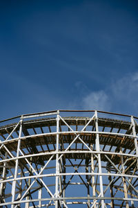 Low angle view of ferris wheel against blue sky