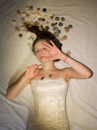 Portrait of young woman standing against wall