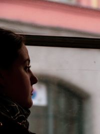 Portrait of young man looking through window