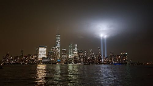 Illuminated buildings in city against sky at night