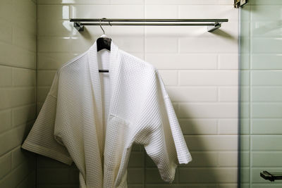 Bathrobe hanging against wall in bathroom