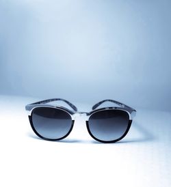 Close-up of sunglasses on table against blue background